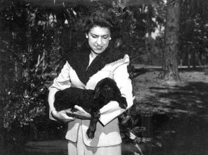 Mrs Bill Davis wearing pelts of Karakul fur & holding a lamb